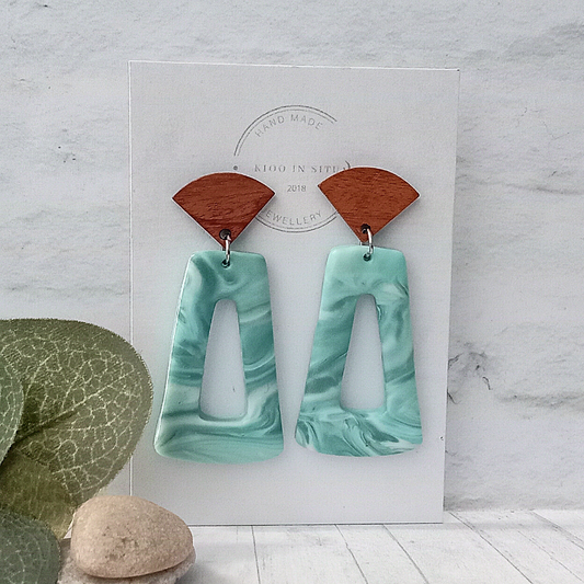 Make a splash with these handmade, eye-catching earrings! Featuring a soft blue and grey marble effect polymer clay that reflects the ocean, each earring is paired with a Walnut Wood Ear Stud for extra comfort.