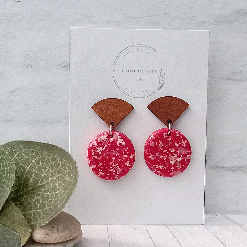These handmade earrings are crafted with premium polymer clay in a pink and white round design.